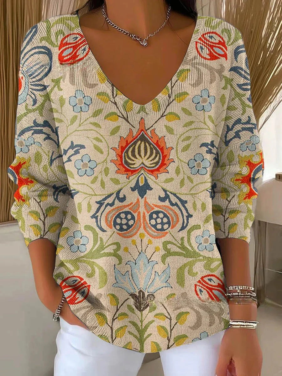 Elegancki i wygodny beżowy sweter z długim rękawem, ozdobiony pięknym kwiatowym nadrukiem i dekoltem w serek.