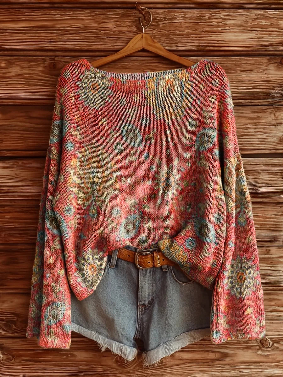 Elegancki i wygodny sweter w kolorze brzoskwiniowo-różowym z długim rękawem i okrągłym dekoltem, ozdobiony pięknym kwiatowym nadrukiem.