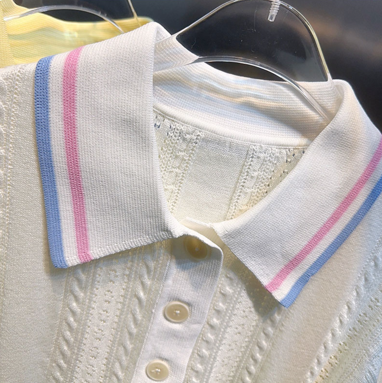 Klasyczny, biały, dzianinowy top polo w stylu francuskim z krótkim rękawem i kołnierzykiem