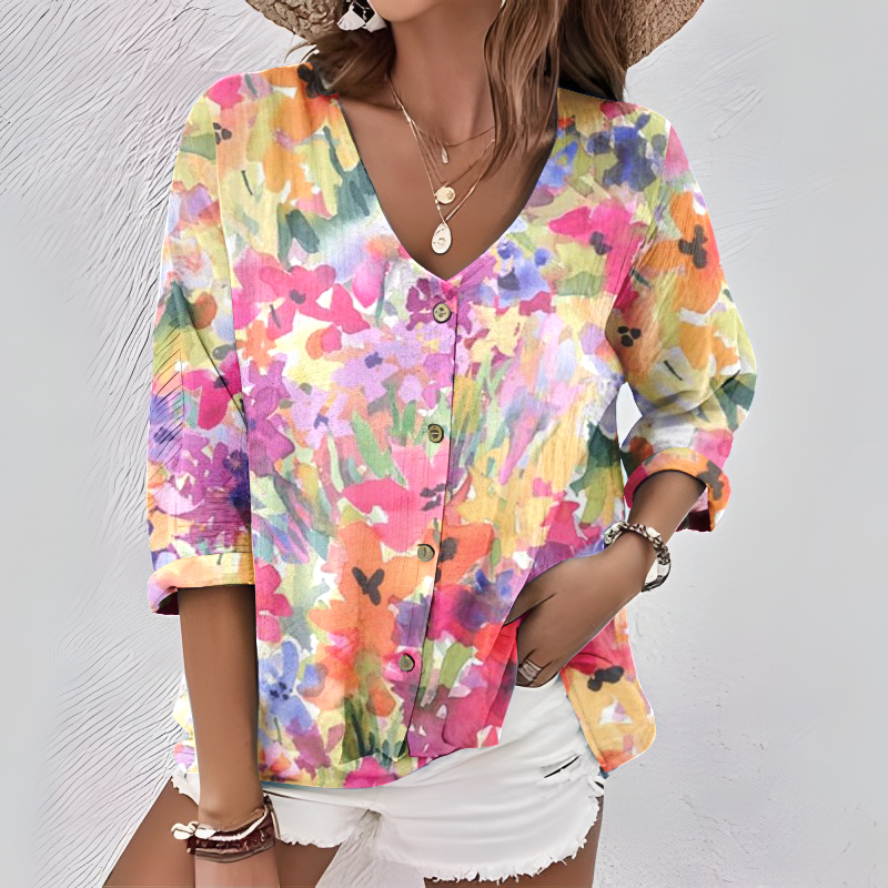 Ta elegancka i wygodna koszula wyróżnia się różowym, kwiatowym wzorem, dekoltem w serek, rękawami o długości 3/4 i zapięciem na guziki.