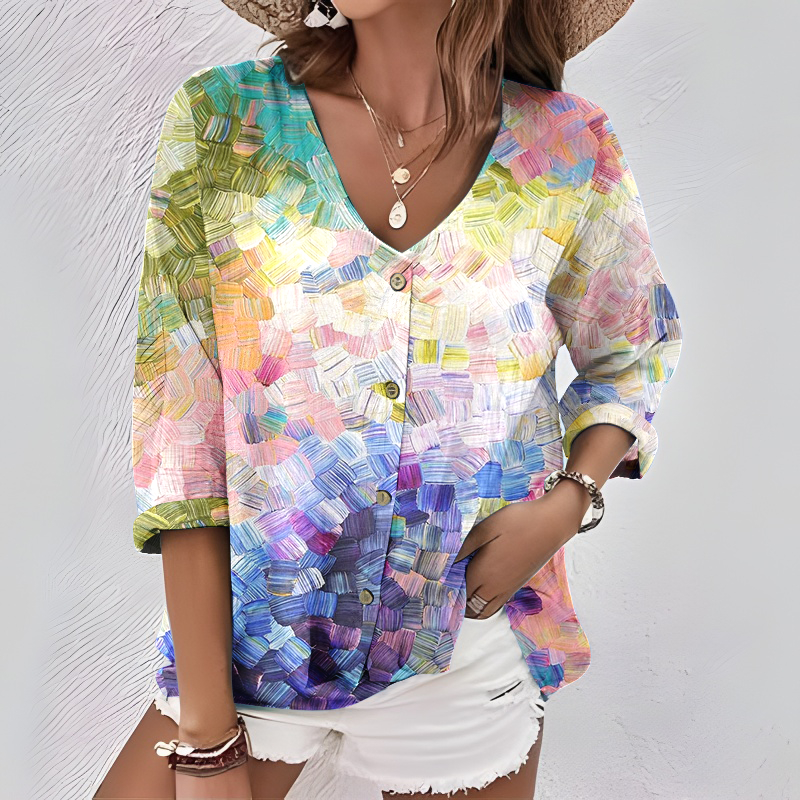 Elegancka i wygodna koszula z żywym, blokowym wzorem kolorystycznym, dekoltem w serek, rękawami o długości 3/4 i zapięciem na guziki.