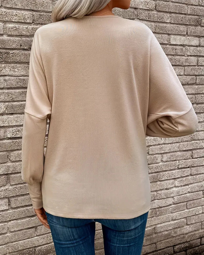 Ten stylowy i uniwersalny top w jednolitym kolorze ma plisowany design, który jest zarówno wyszczuplający, jak i elegancki.