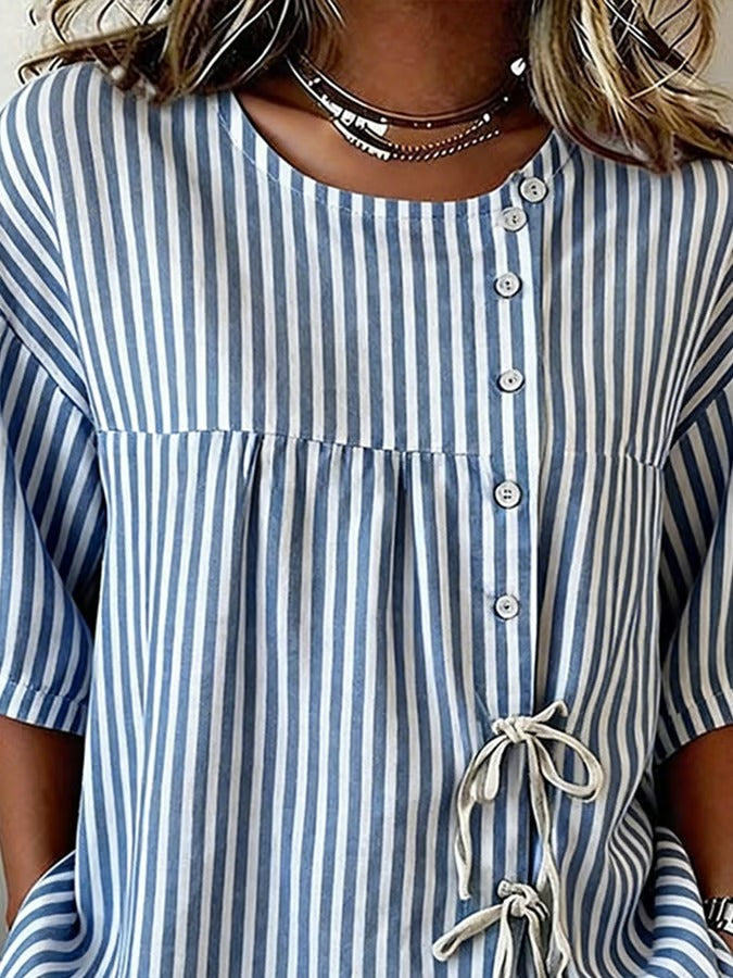 Ta niebieska koszula w drobne prążki, zapinana na guziki, jest wygodna, swobodna i uniwersalna.