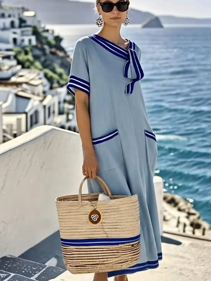 Elegancka i wygodna długa sukienka z niebieskiego materiału w paski z bawełny i lnu z muszką i kieszeniami