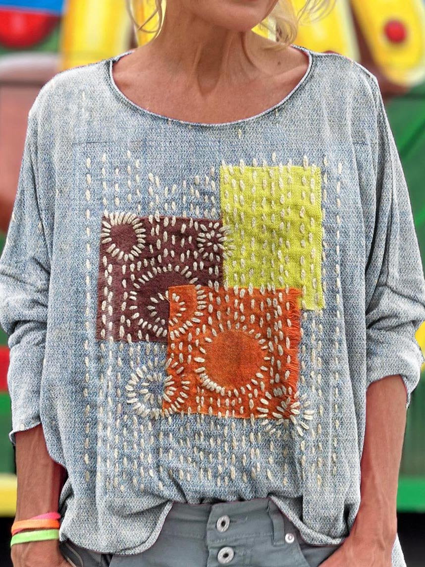 Elegancki i wygodny szary top z okrągłym dekoltem ozdobiony kolorowym wzorem w kratkę.