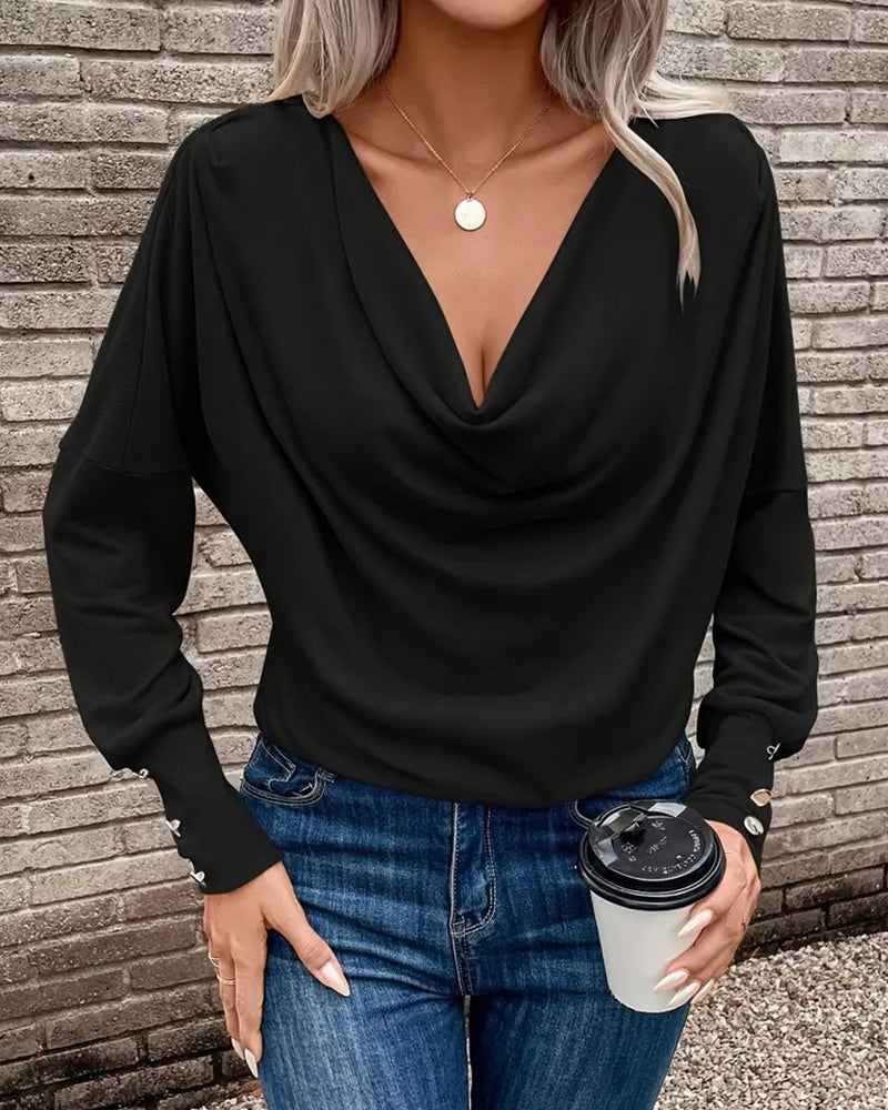 Ten stylowy i uniwersalny top w jednolitym kolorze ma plisowany design, który jest zarówno wyszczuplający, jak i elegancki.