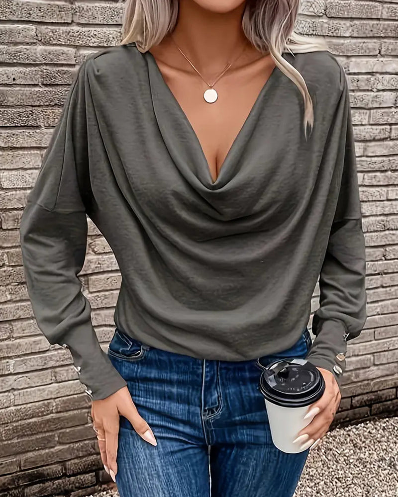 Ten stylowy i uniwersalny top w jednolitym kolorze ma plisowany design, który jest zarówno wyszczuplający, jak i elegancki.