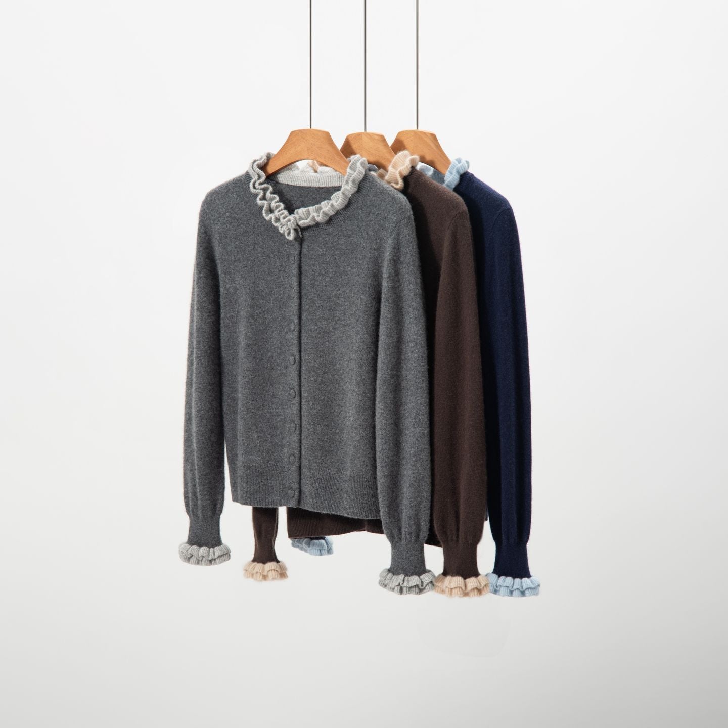 Elegancki i wygodny dwuczęściowy kardigan w jednolitym kolorze z kontrastującymi dzianinowymi falbankami przy kołnierzu i mankietach.