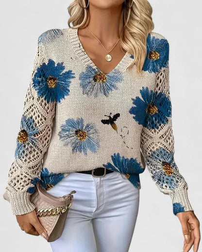 Elegancki i luksusowy top dzianinowy w stylu boho z kwiatowym wzorem, dekoltem w serek, długimi rękawami i ażurowymi rękawami.