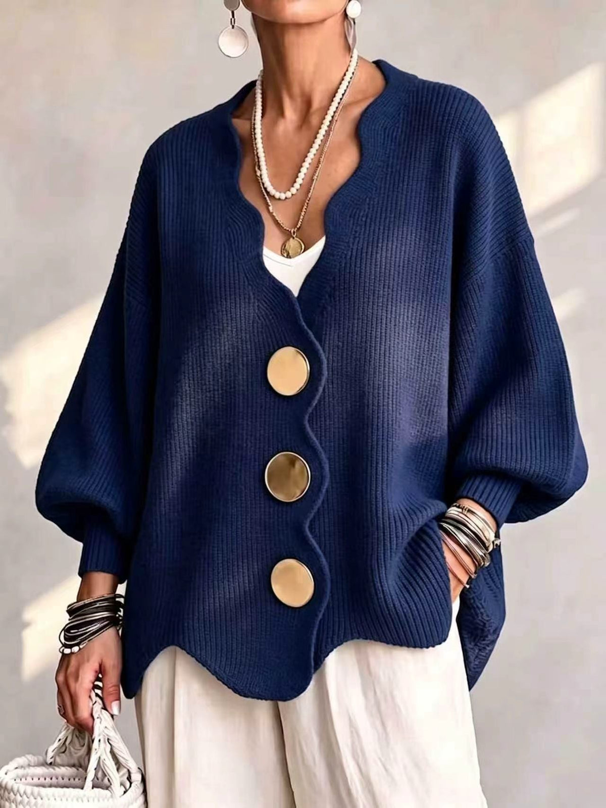 Ten jednokolorowy sweter jest miękki w dotyku i zapinany na duże guziki. Łączy w sobie wygodę i elegancki styl.