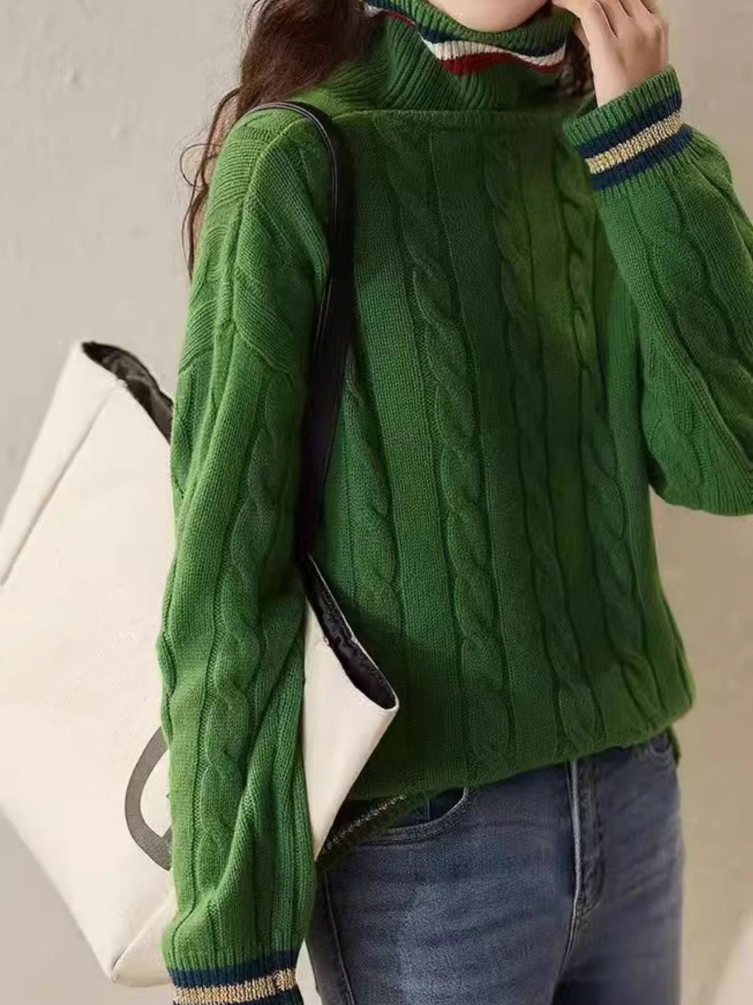 Elegancki i wygodny golf w jednolitym kolorze z poziomymi paskami przy dekolcie i mankietach.