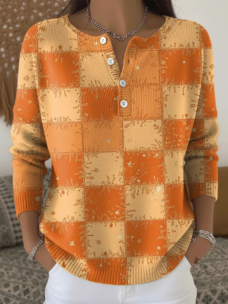 Elegancki i wygodny sweter w pomarańczowo-żółte bloki kolorystyczne z ozdobnymi guzikami przy dekolcie