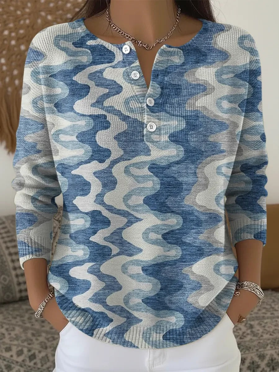 Elegancki i wygodny sweter, ozdobiony nieregularnymi, kontrastującymi niebieskimi paskami i półotwartym dekoltem.