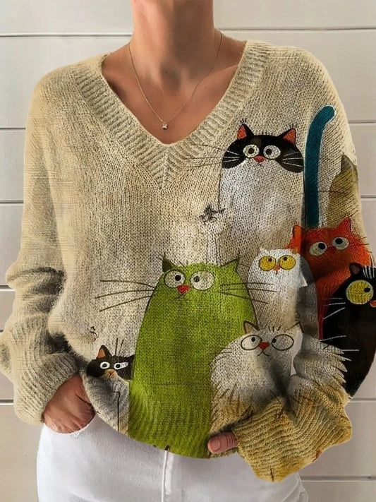 Elegancki i wygodny beżowy sweter z długim rękawem i dekoltem w serek, ozdobiony nadrukiem przedstawiającym kreskówkowego kota.