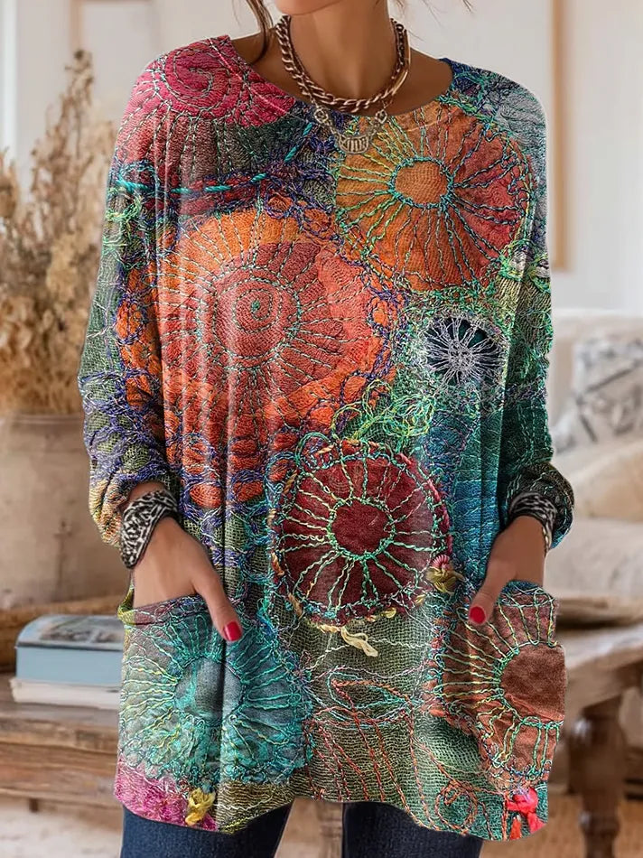 Elegancki i wygodny sweter kaszmirowy ozdobiony żywym wzorem kwiatowym, z okrągłym dekoltem i kieszeniami.