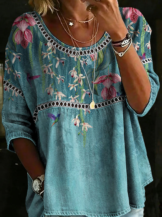 Luźna, wygodna niebieska koszula damska z długimi rękawami, okrągłym dekoltem i delikatnym kwiatowym nadrukiem.