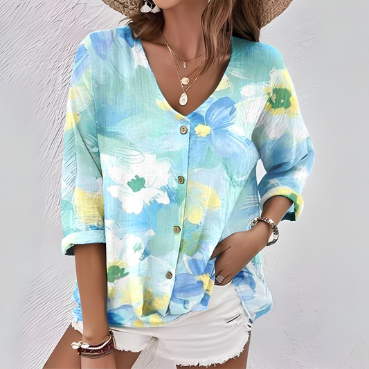 Ta elegancka i wygodna koszula wyróżnia się niebieskim wzorem kwiatowym, dekoltem w serek, rękawami o długości 3/4 i zapięciem na guziki.