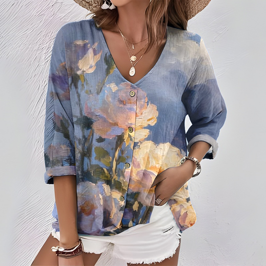 Ta elegancka i wygodna fioletowa koszula ma kwiatowy wzór, dekolt w serek, rękawy o długości 3/4 i zapięcie na guziki.