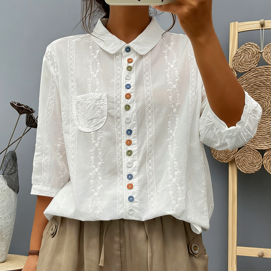 Biała bawełniana koszula damska z krótkim rękawem i kolorowymi guzikami jest stylowa i emanuje elegancją.