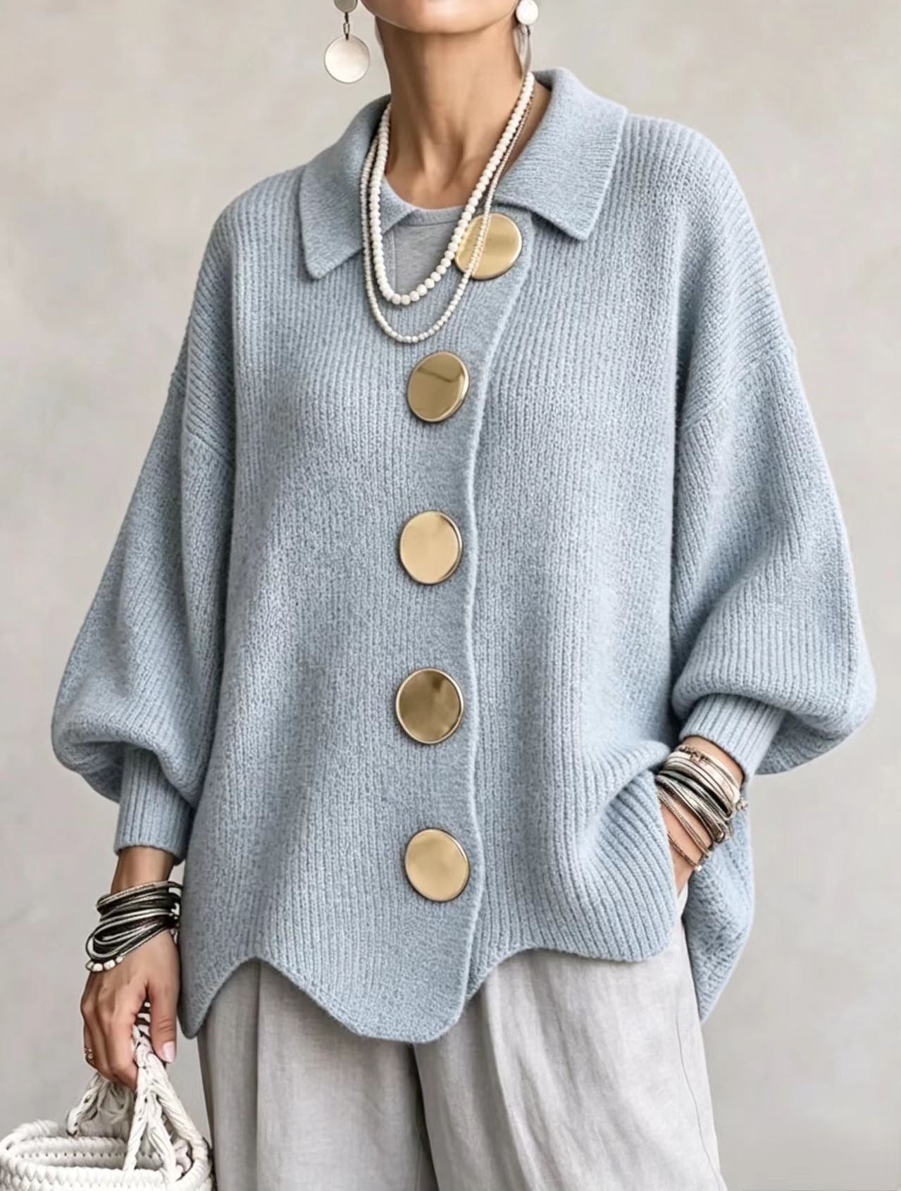 Ten sweter w stylu retro zdobią duże metalowe guziki, które nadają mu swobodny i luźny styl.