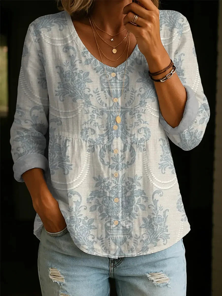 Elegancka i wygodna biała koszula z długim rękawem, z jasnoniebieskim nadrukiem kwiatowym i zapięciem na guziki.