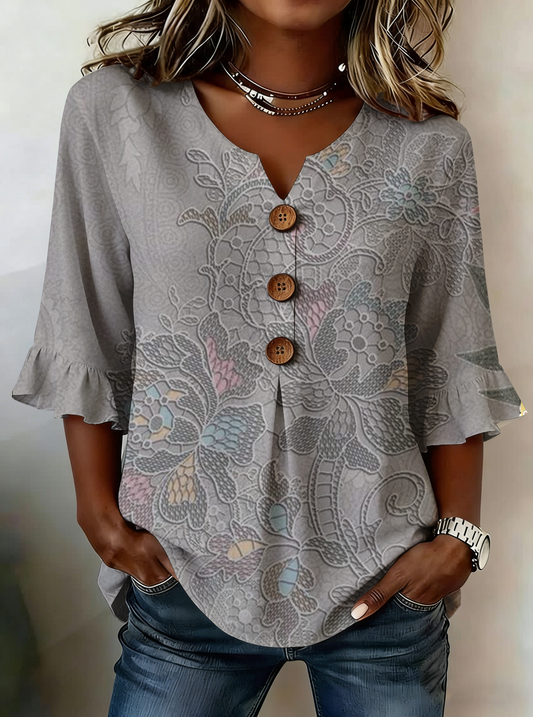 Elegancka i wygodna szara koszula damska z delikatnym kwiatowym nadrukiem, dekoltem w serek i falbankami przy mankietach.