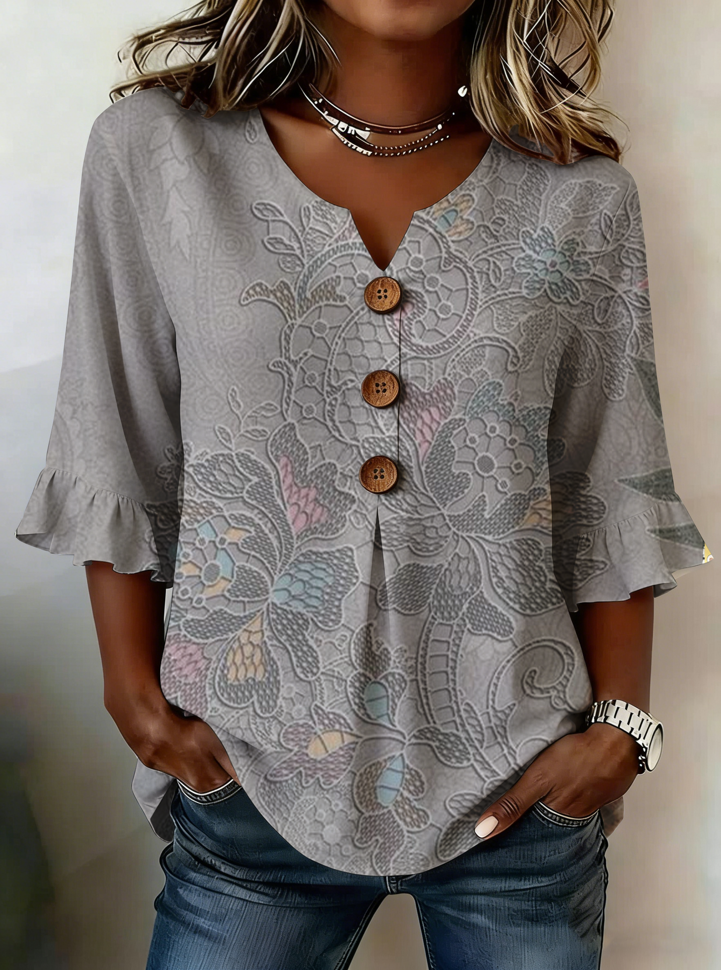 Elegancka i wygodna szara koszula damska z delikatnym kwiatowym nadrukiem, dekoltem w serek i falbankami przy mankietach.