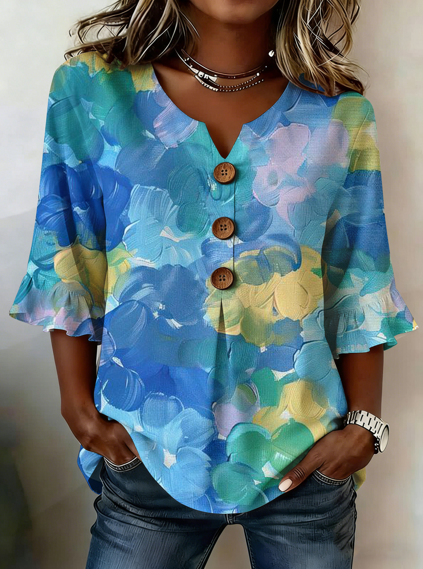 Elegancka i wygodna koszula z niebieskim kwiatowym nadrukiem, dekoltem w kształcie litery V i mankietami z falbaną.