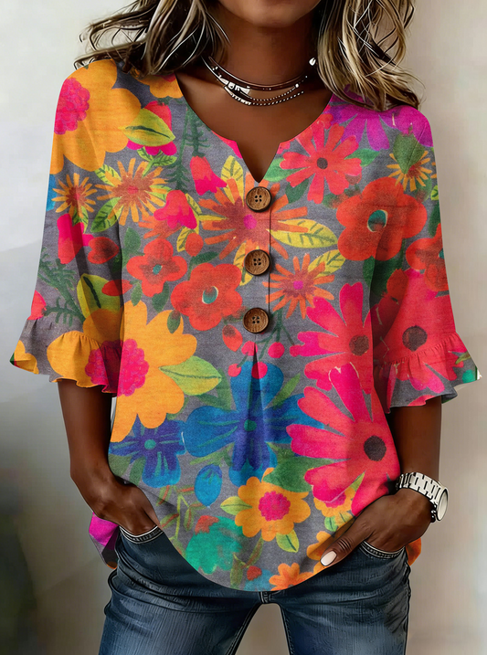 Elegancka i wygodna koszula w jasny kwiatowy wzór, dekolt w kształcie litery V, mankiety z falbaną.