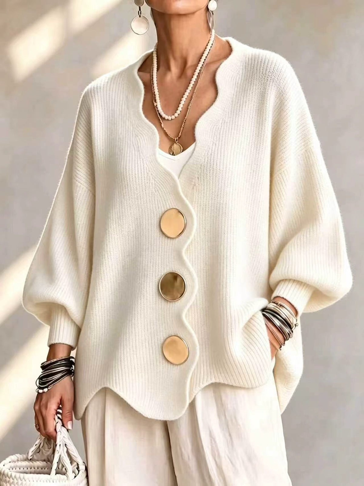 Ten jednokolorowy sweter jest miękki w dotyku i zapinany na duże guziki. Łączy w sobie wygodę i elegancki styl.