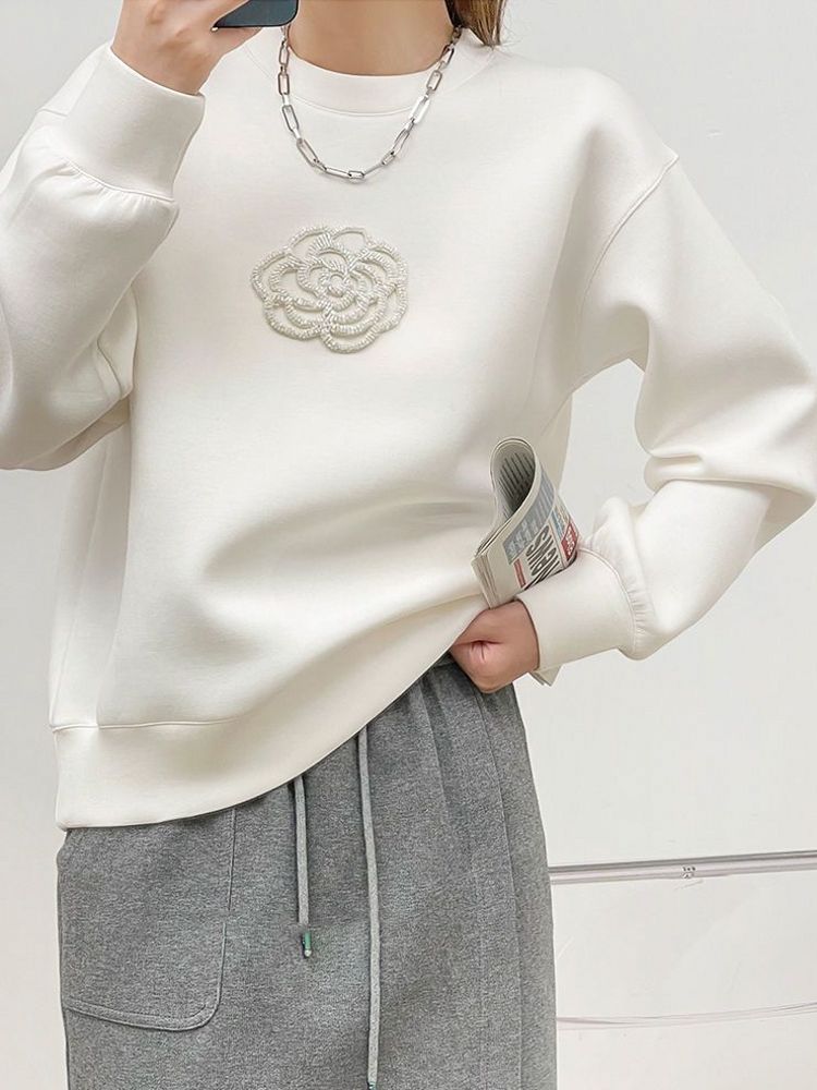 Elegancka i wygodna biała bluza ozdobiona pięknym żakardowym wzorem 3D z kwiatowym wzorem.