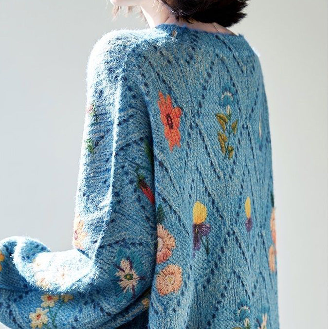 Elegancki i wygodny, dzianinowy sweter w kolorze niebieskim, z okrągłym dekoltem, ażurowym wzorem i kwiatowymi zdobieniami.