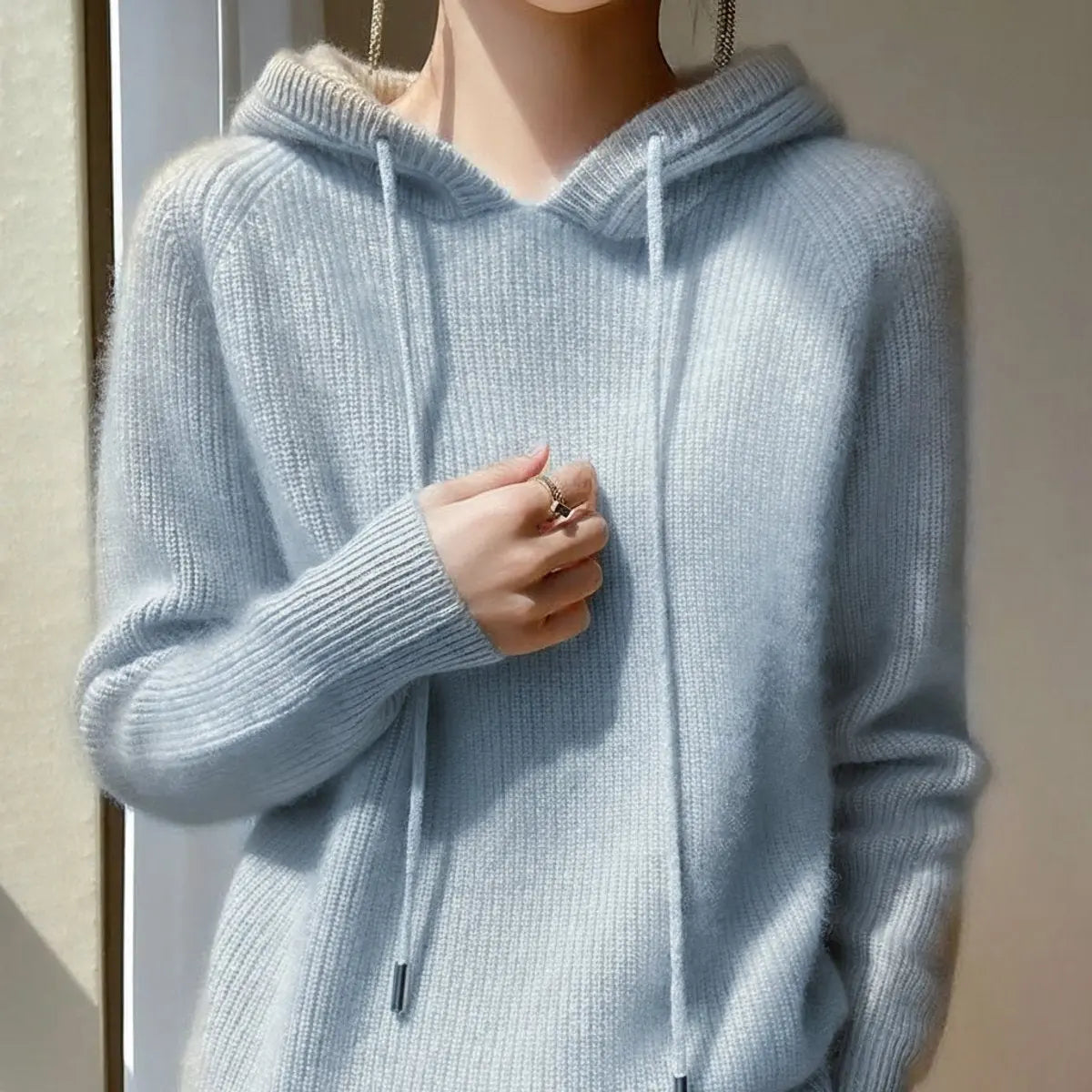 Ten jednolity sweter ma kaptur, jest miękki w dotyku oraz wygodny i elegancki.