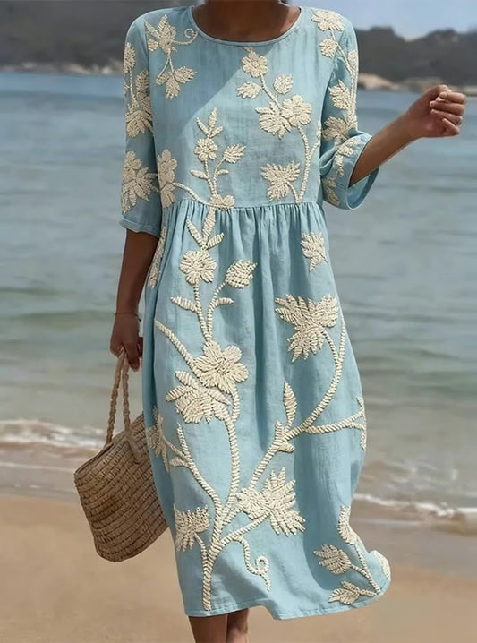 Elegancka i wygodna sukienka z kwiatowym nadrukiem i rękawami o średniej długości.