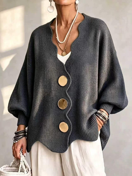 Ten jednokolorowy sweter jest miękki w dotyku i zapinany na duże guziki. Łączy w sobie wygodę i elegancki styl.