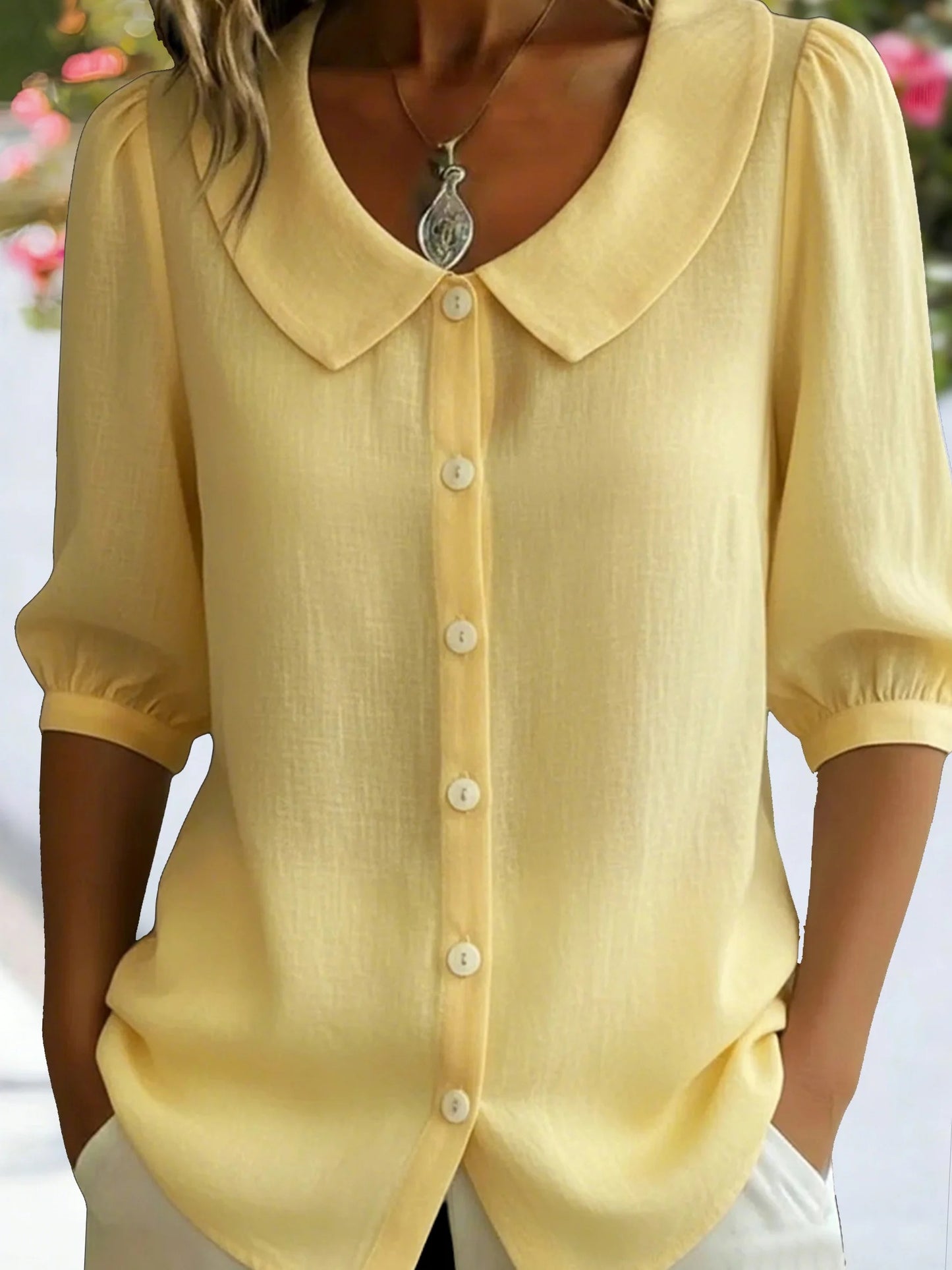 Elegancka i wygodna monochromatyczna koszula z krótkim rękawem i kołnierzykiem typu Piotruś Pan oraz dopasowanymi mankietami.