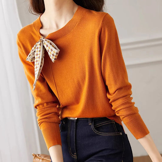 Klasyczny, jednokolorowy kardigan kaszmirowy w stylu retro, miękki w dotyku, z kokardą przy dekolcie.