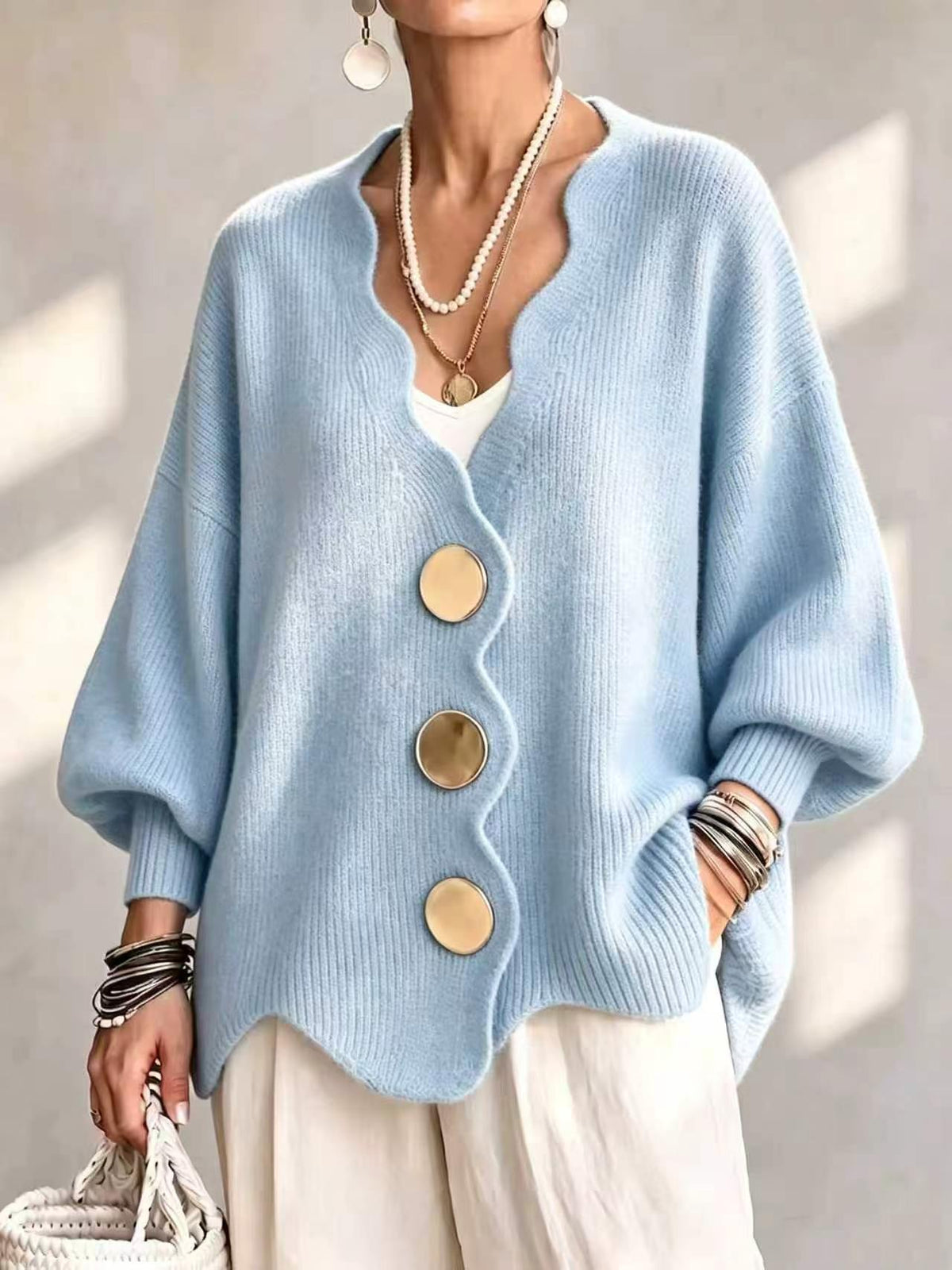 Ten jednokolorowy sweter jest miękki w dotyku i zapinany na duże guziki. Łączy w sobie wygodę i elegancki styl.