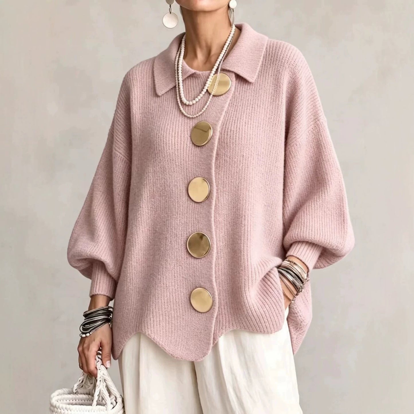 Ten sweter w stylu retro zdobią duże metalowe guziki, które nadają mu swobodny i luźny styl.