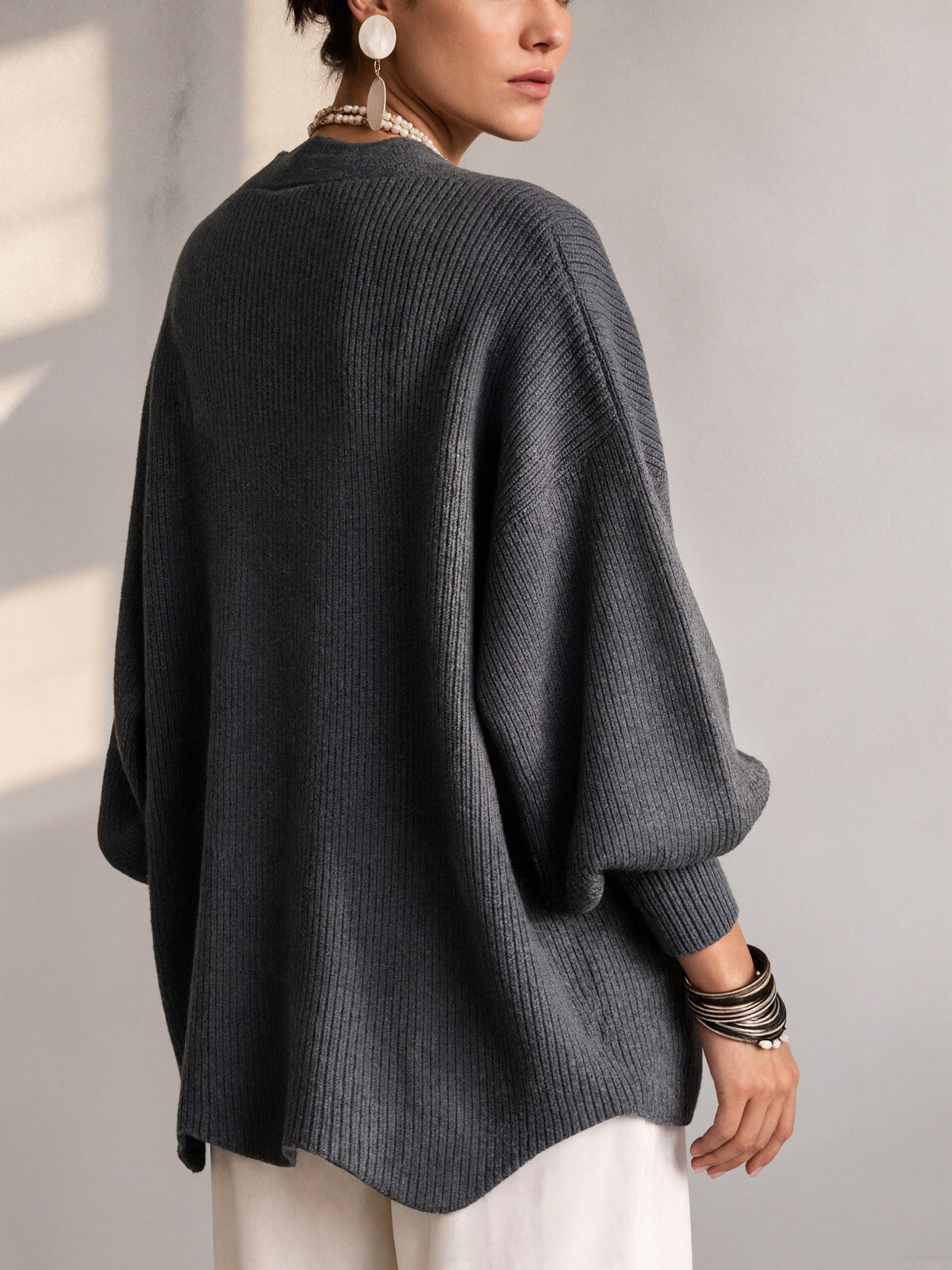Ten jednokolorowy sweter jest miękki w dotyku i zapinany na duże guziki. Łączy w sobie wygodę i elegancki styl.