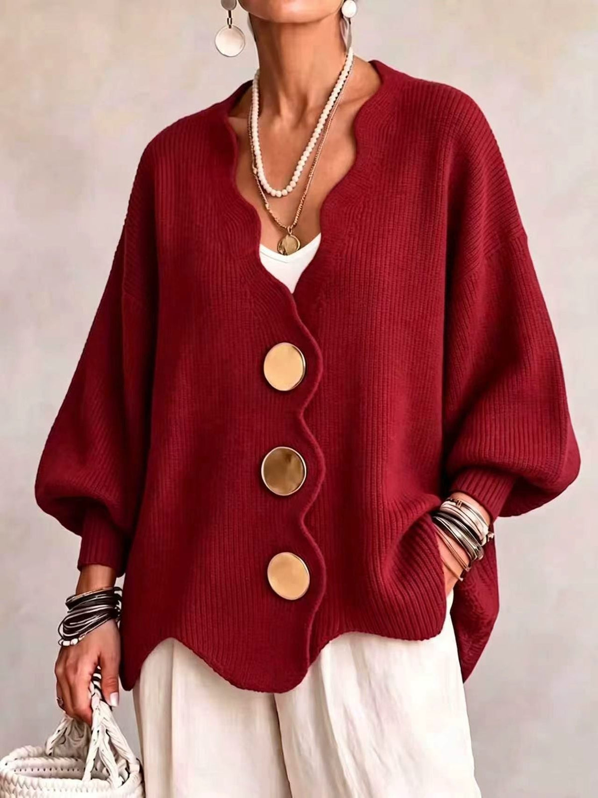 Ten jednokolorowy sweter jest miękki w dotyku i zapinany na duże guziki. Łączy w sobie wygodę i elegancki styl.