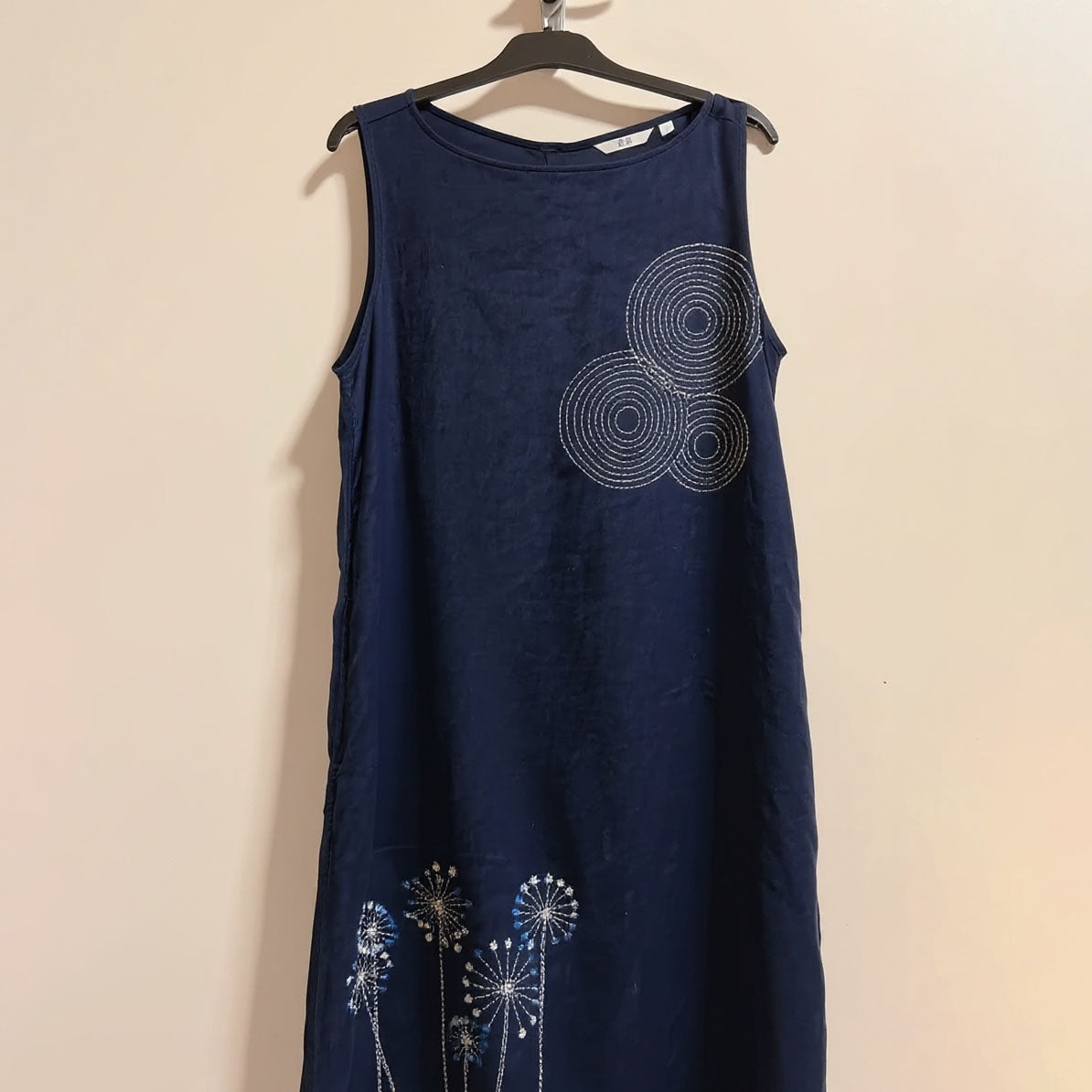 Stylowa, ciemnoniebieska sukienka ozdobiona delikatnymi, minimalistycznymi kwiatowymi nadrukami, która nadaje jej świeży i elegancki wygląd.