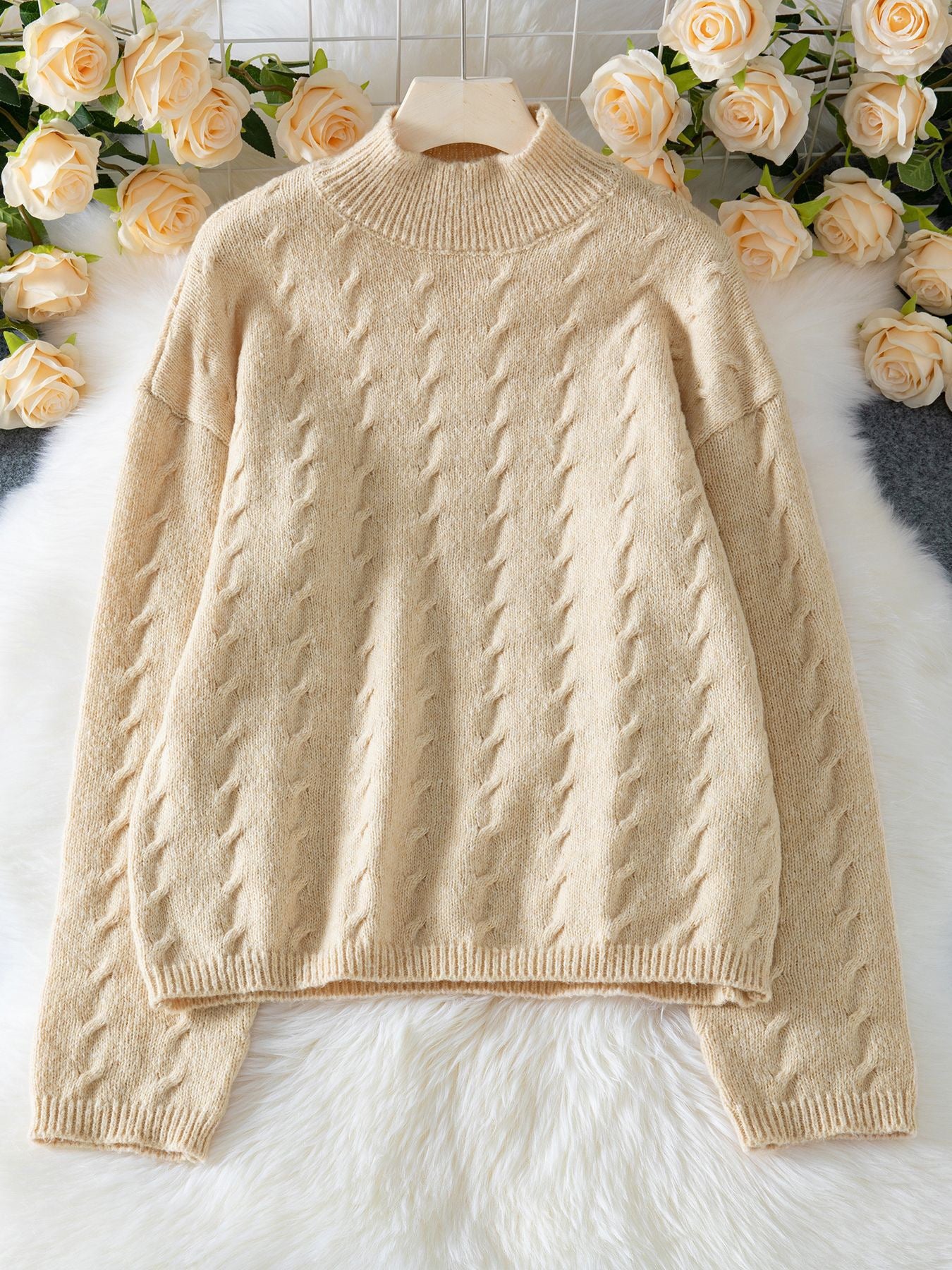 Elegancki i wygodny beżowy sweter wykonany ze splotu warkoczowego.