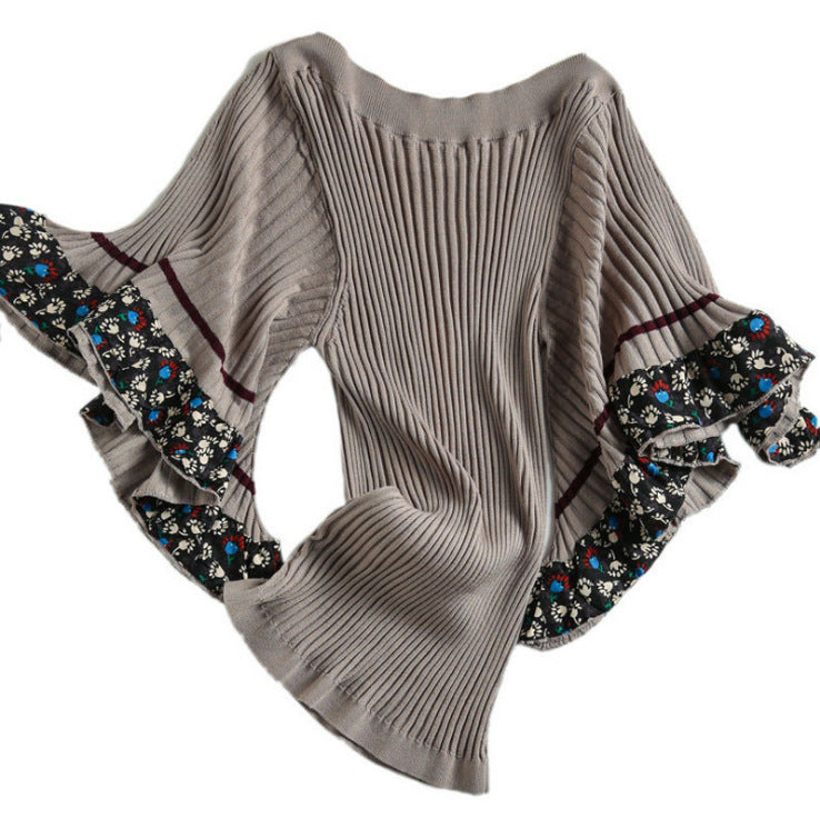 Luksusowy, nowy sweter w stylu retro z szerokimi mankietami ozdobionymi kwiatowymi wzorami.