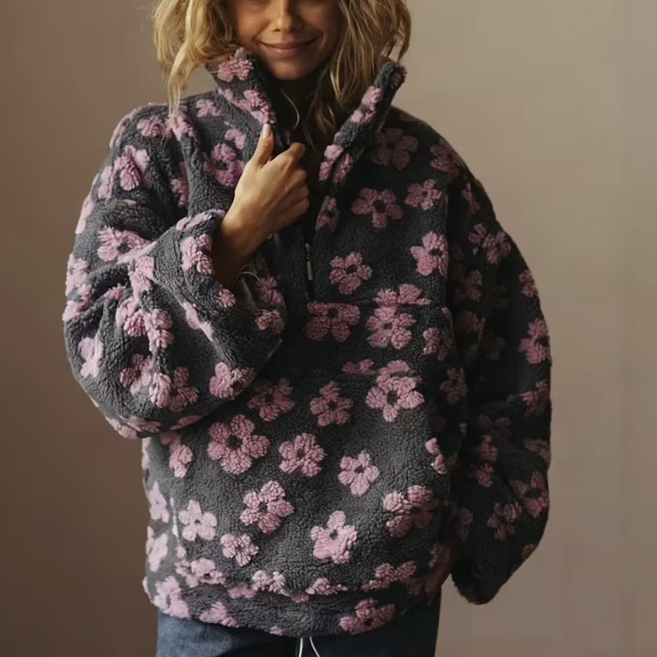 Elegancki i wygodny top typu sherpa z kwiatowym nadrukiem, zapięciem na zamek przy dekolcie i kieszeniami z przodu