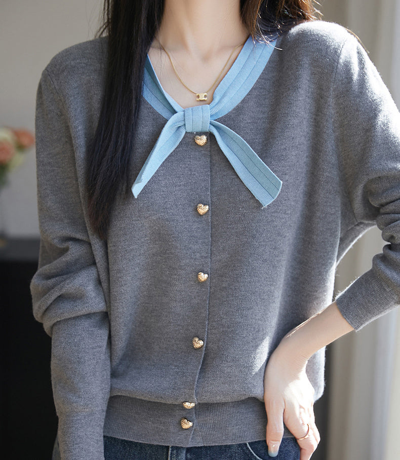 Klasyczny sweter kardigan z kaszmiru w stylu retro, miękki w dotyku, z kokardką przy dekolcie.