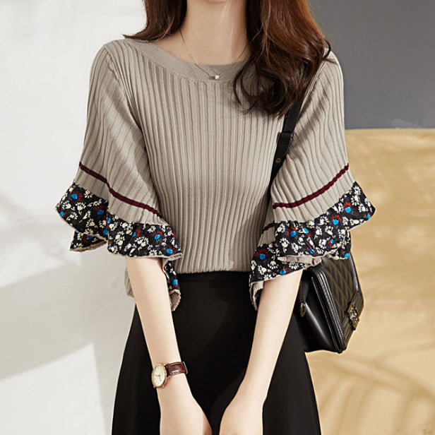 Luksusowy, nowy sweter w stylu retro z szerokimi mankietami ozdobionymi kwiatowymi wzorami.