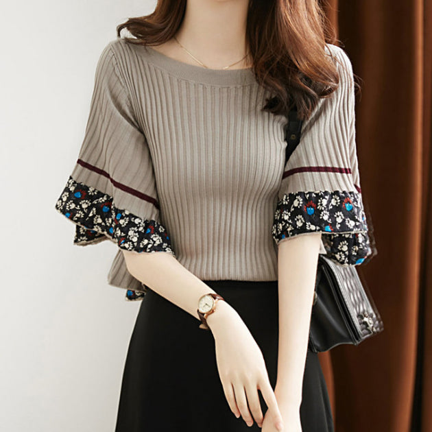 Luksusowy, nowy sweter w stylu retro z szerokimi mankietami ozdobionymi kwiatowymi wzorami.