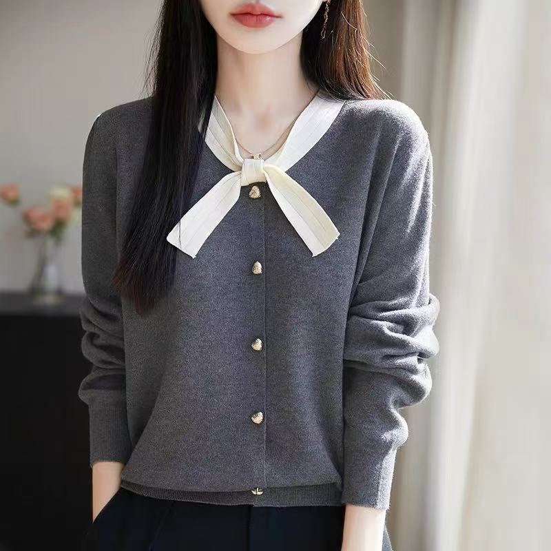 Klasyczny sweter kardigan z kaszmiru w stylu retro, miękki w dotyku, z kokardką przy dekolcie.