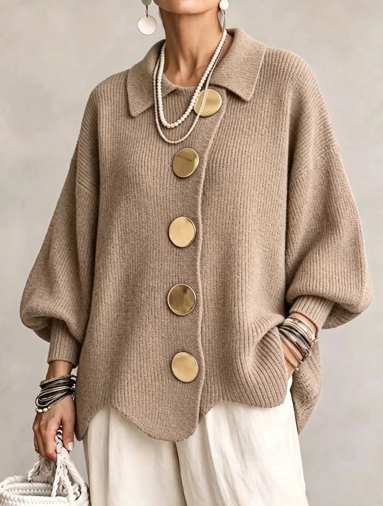 Ten sweter w stylu retro zdobią duże metalowe guziki, które nadają mu swobodny i luźny styl.